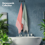 Honeycomb-Foutas in Lachsrosa und Salbeigrün an Haken über einer Badewanne