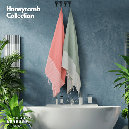 Honeycomb-Foutas in Lachsrosa und Salbeigrün an Haken über einer Badewanne