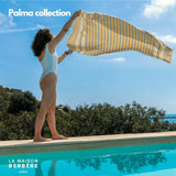 Frau schwingt eine gelb gestreifte Palma-Fouta am Pool