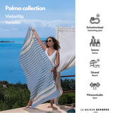 Frau am Meer mit einer orange-blau gestreiften Palma-Fouta